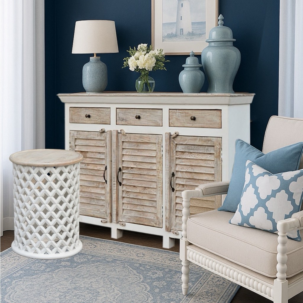 Stylowa komoda Hampton z litego drewna mango, z żaluzjowymi frontami w jasnym wnętrzu z błękitnymi akcentami i eleganckim wystrojem w klimacie nadmorskim.