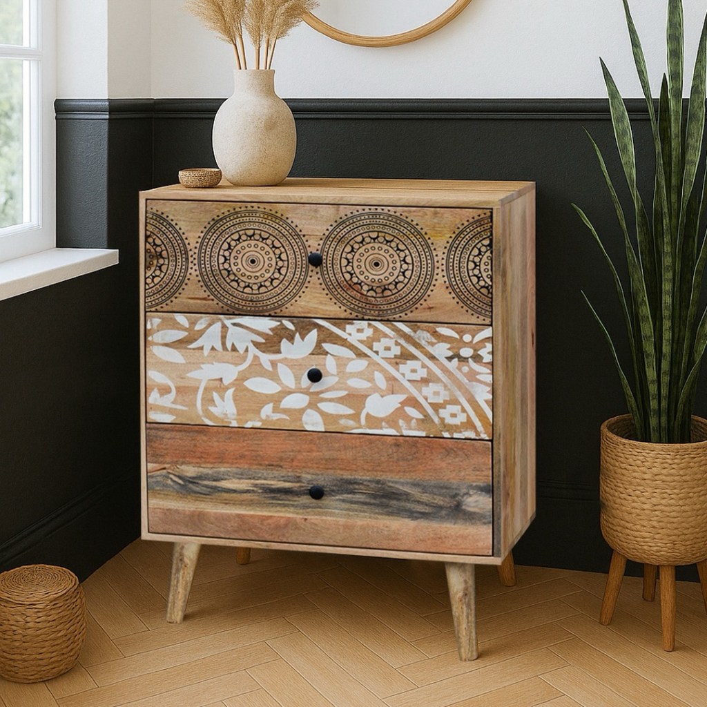 Drewniana komoda Qumin z mango w stylu boho, ozdobiona ręcznie malowanymi frontami w orientalne wzory, ustawiona w naturalnym, jasnym wnętrzu z roślinami i dekoracjami z trawy pampasowej.